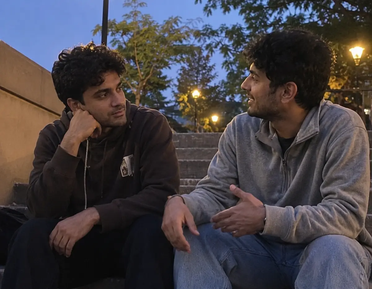 Two friends leaning in during a deeper conversation at dusk outdoors