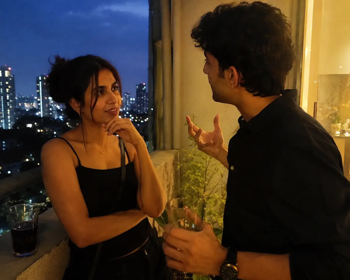 Two people on a balcony mid-conversation, one listening intently while the other lights up mid-story